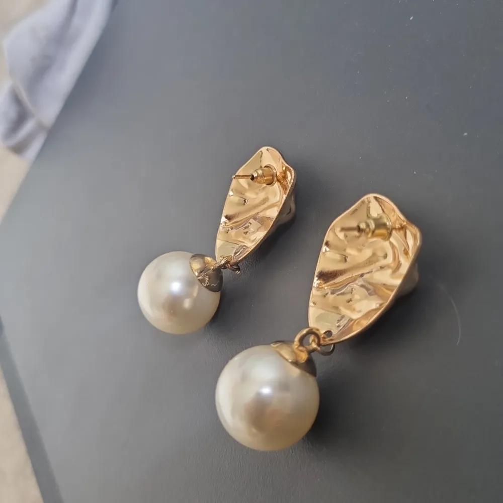 Stora örhängen i fake guld och en varsin pärla, säljer för att de är för stora för mina öron. Accessoarer.