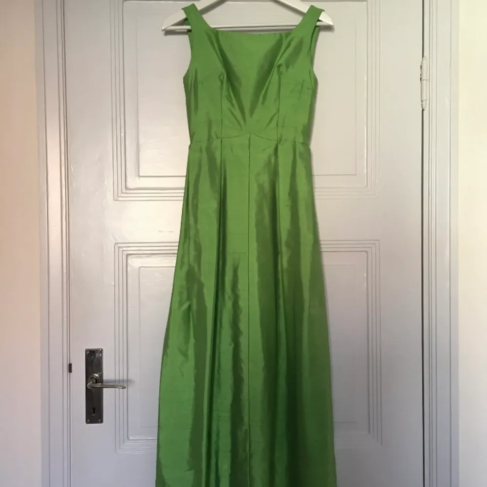 Vacker grön balklänning. Handsydd. Köpt second hand, men tyvärr lite liten för mig. Längd: ca 134 cm, Midjemått ca 31 cm, Mellan ärmhålen: ca 42 cm.. Klänningar.