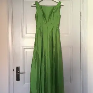 Vacker grön balklänning. Handsydd. Köpt second hand, men tyvärr lite liten för mig. Längd: ca 134 cm, Midjemått ca 31 cm, Mellan ärmhålen: ca 42 cm.