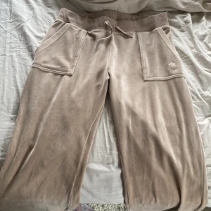 Juicy couture - säljer mina beige juicy byxor i storleken M. Har använt cirka 3-4 gånger och metallsnörrerna har åkt av så säljer dom väldigt lågt. Kom privat för mer bilder:)