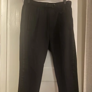 Diesel finbyxor med satin rand - Diesel finbyxor med satin rand längst benen. Väldigt lite använda har en inbyggd reså med bälte runt midjan. Regular fit så passar även M. Nypris ca 1500kr