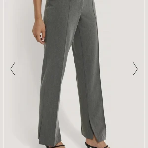 Kostymbyxor med slits - Sprillans nya grå kostymbyxor med slits. Endast provade men skickades aldrig tillbaka när de köptes, därmed säljes dem. Nypris 599:- Säljes för 200:-