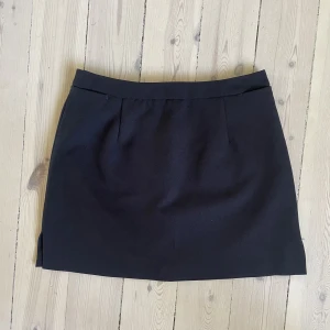 Sisley minikjol - Den perfekta, svarta minikjolen med liten slits från Sisley, storlek XS/34. Superfint skick! 