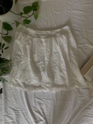 Vit spetskjol - Vit kjol i spets. Tre lager. Går ned till knäna på mig som är 172 cm lång. Bra skick. Stretchig.