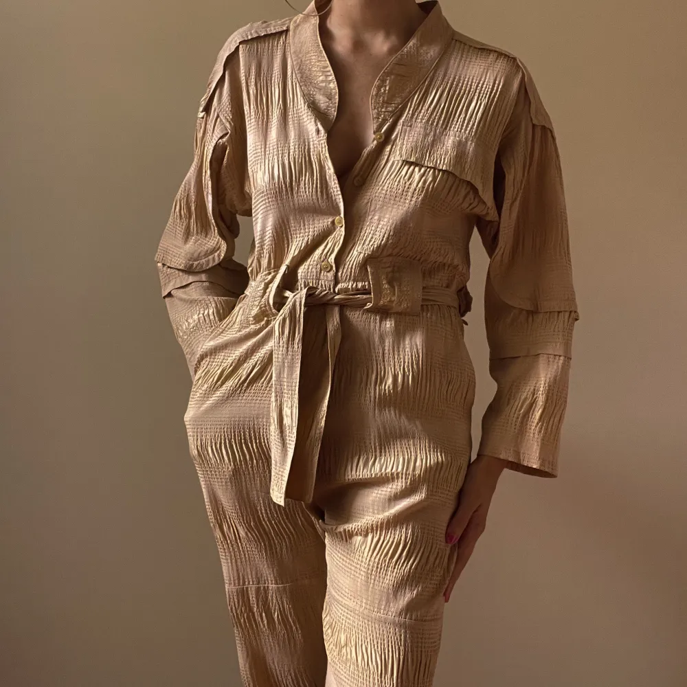 Rachel Comey made in New York tan jumpsuit 1 chest pocket  2side frontal pockets 2back flap pockets  button down opening, waist strap Rachel Comey Buttons 2 minor stains one in the front, one in back not visible when worn  size XS. Jeans & Byxor.
