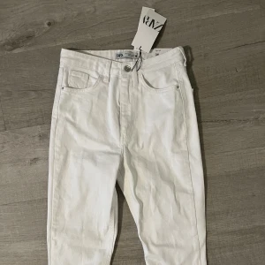 Vita jeans strl 36 - Säljer dessa oanvända vita jeans köpta från zara. Högmidjade. Slit nere på benen. Stl 36 