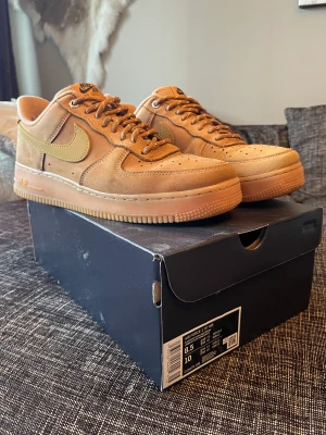 Nike Air Force 1 ’07 Wheat - Använde dessa förra vintern och dem är i använt men bra skick. Dem är varma och fodrade så det är ett bra par sneakers för vintern! Storlek: EU 42