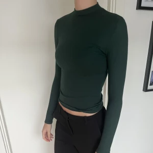 Grön Polo tröja  - Grön låg polotröja från pull and bear. Använd men i bra skick 