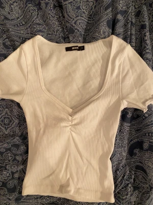 Vit tshirt från Bik Bok - Fin crop top med urringning från BikBok. Säljer då jag inte använt den och rensar garderoben. Perfekt under någon kofta nu på hösten och ger fint cleavage 🤍