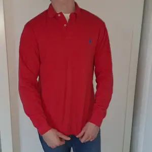 En röd Polo Ralph Lauren skjorta i medium modell och ser relativt ny ut.  Bredd: 50 Längd: 70