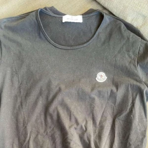 Moncler - En ljusgrå t-shirt från moncler. Legat i flyttlåda därför den ser lite tilltyckad ut men den är hel och fin! 