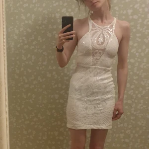 Vit skimrande miniklänning - Bedårande! Aldrig kommit till användning dock :/  Vit tight fodral klänning med paljetter och div utsmyckningar.