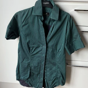 Randig skjorta - Grön-lila randig kortärmad skjorta köpt på stadsmissionen. Storlek M.