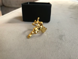 Guldpläterad ring i justerbar storlek  - Guldpläterad ring formad som droppande smält guld. Går att justera i omkrets. Droppen ovanpå är ca 25 mm lång. Säljes i ask.   Säljer även matchande örhängen och ring. Hämtas vid Tekniska Högskolan eller skickas.