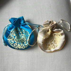 Två smyckespåsar - Två smyckespåsar, en beige och en blå. Frakt spårbart (29 kr) eller med post (15 kr).