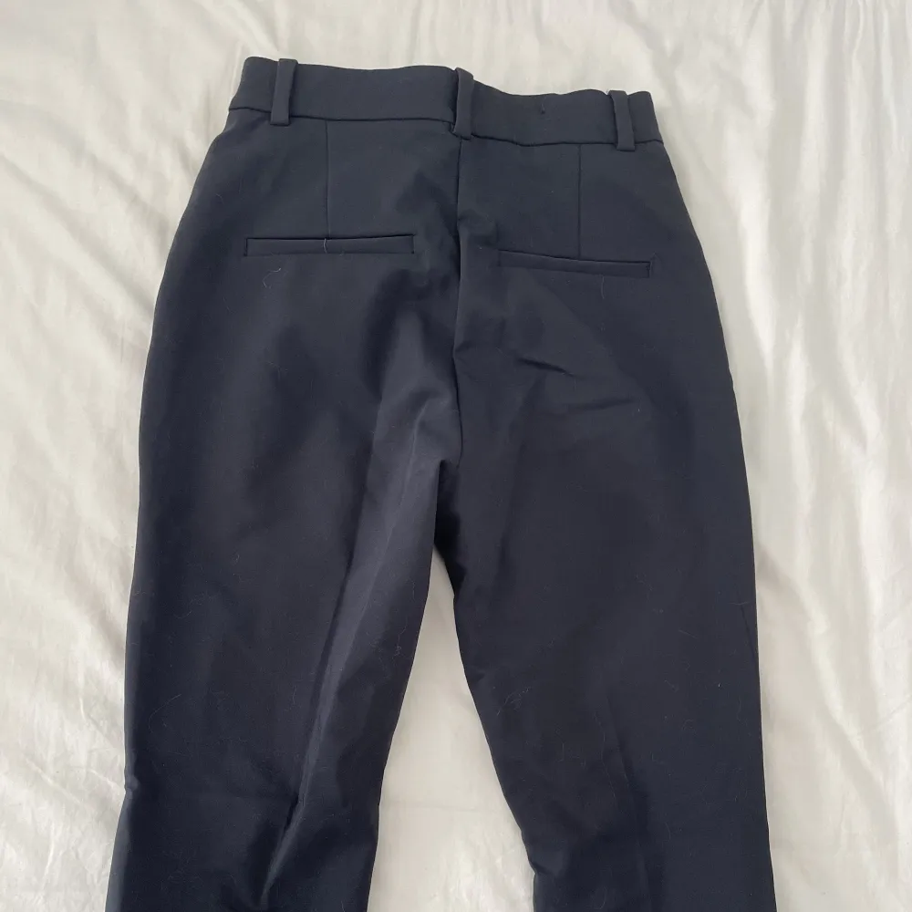 Marinblå kostymbyxor med fickor från h&m i storlek 34. Jeans & Byxor.