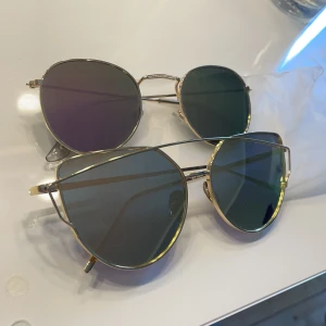 Solglasögon - Säljer två par solglasögon, ena paret har ett blått ljus som ni kan se och de andra paret har ett ljustbrunt ljus Båda är i bra skick Dem med brunt ljus är lite mindre Köparen står får frakten💗