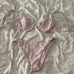 Bikini - Vit bikini med rosa blommor på. Endast använd ett par gånger. I super bra skick men den kommer tyvärr till användning.