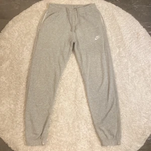 Nike mjukisbyxor - Säljer ett par gråa mjukisbyxor i från Nike i storlek S. Dock med ett litet hål höger benet.