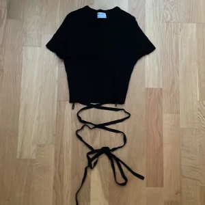 Topp med snörning - Kort topp med snörning som man kan knyta lite hur man vill vid magen! Bra skick!