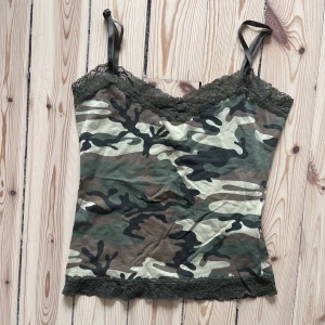 camo linne med spets  - Gulligt linne! Använt en gång på en mtv fest, inhandlad 2hand på beyond retro. Puss och kram