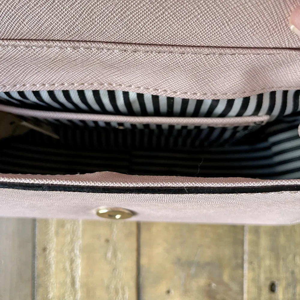 Oanvänd Kate Spade väska.Ljusrosa läder.Strl 20x17 cm.Kan skicka,då betalar mottagaren frakten på 69kr.. Asusteet.
