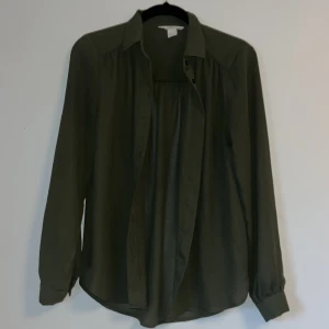 Mörkgrön blus - Väldigt fin blus utan tecken på användning. Ingår även en extra knapp