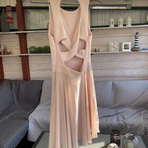 Fin sommar klänning i storlek S. Klänningen är ljusrosa och är korsad i ryggen. 