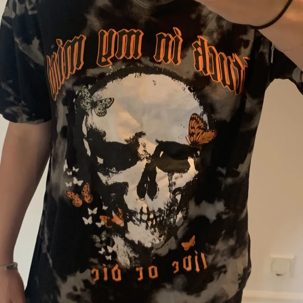 En t-shirt med en döskalle som tryck, får inte till användning längre då jag inte gillar färgen orange 🙅‍♀️. T-shirts.