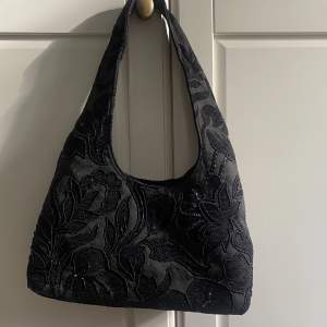 Supersnygg mellanstor/liten svart väska med paljetter och pärlor i mönster. Köpt second hand men skick som ny🖤