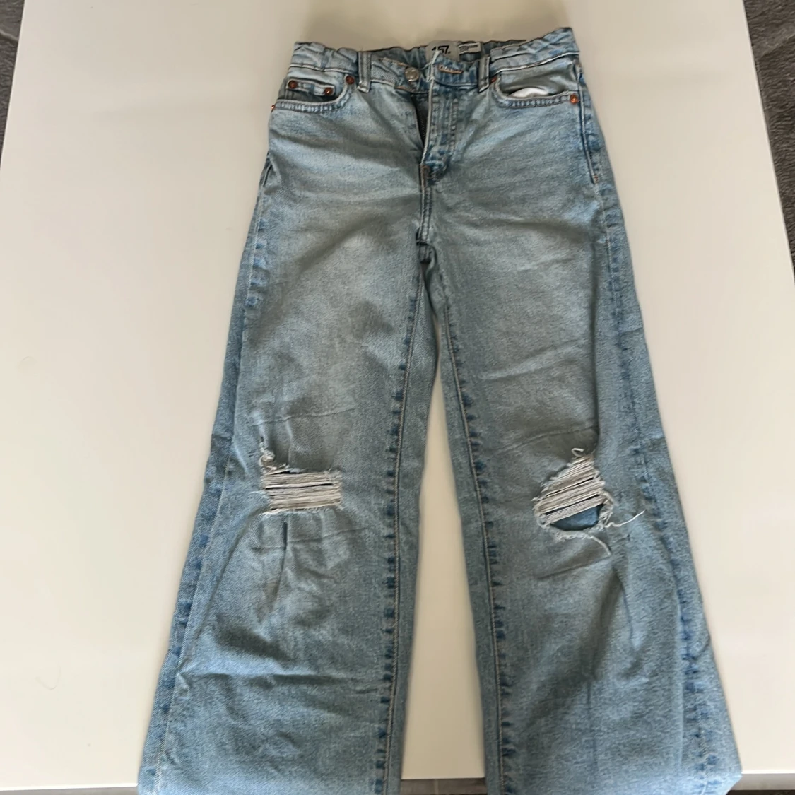 Blåa utsvängda jeans