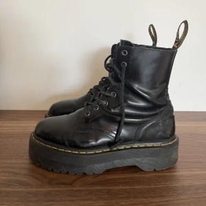 Dr. Martens platform stl 39 - Dr. Martens jadon platform i stl 39! Välanvända med fortfarande så snygga och i gott skick. Däremot hackar kedjan upp sig ibland halvvägs på vänster fot. Därav priset.
