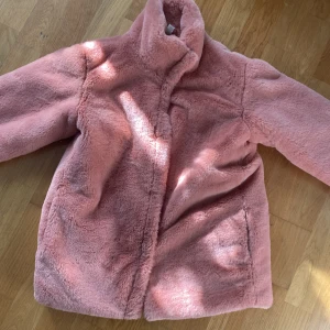 Aprikos/rosa fuskpälsjacka. Stl160 - Som ny:)  Jacka som ej blev använd mera än en gång. Den är som sagt var som ny. Stl 170