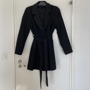 Kappa - Snygg svart kappa från H&M i storlek S, med dolda knappar och knytskärp i midjan.  Perfekt till hösten 🍂   Välanvänd och lite nopprig men inget man tänker på    Nypris 599 kr 🤍