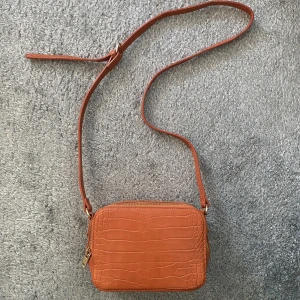 Axelremsväska - Orange axelremsväska. Använd 2 ggr.  Mått 18x13. Märke Pimkie