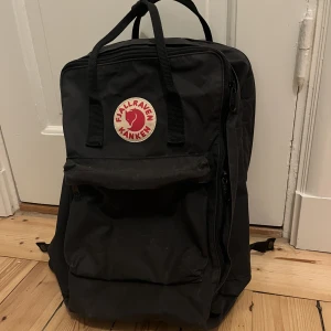 Fjällräven Kånken Laptop 15" Unisex - Ryggsäck från Fjällräven, modell KÅNKEN LAPTOP 15" Unisex i färgen Graphite.   I fint använt skick! Några små fläckar och slitningar, men är inget som stör. Har definitivt mycket kvar att ge! 