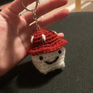 En söt liten svamp nyckelring - En söt liten hemmagjord svamp nyckel ring med ansikte och små armar o ben, man ser knappt armarna och benen men det finns, fint skick, du betalt sjölv för frakten, tryck helst inte på köp nu den strular för mig, den är perfekt att ha på din väska🍄❤️😊