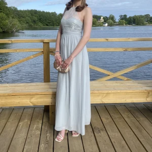 Silverblå baklänning - Säljer min klänning som jag hade på balen i 9an, super fin med spets upptill! Funkar även till andra tillfällen än bal. 