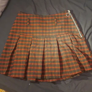 Tjol, röd, svart och grå checkered - tight på mig som 32/32 i jeans skulle säga att den är 38 i stotlek. Köpt 2 år sedan i berlin. Nästan aldrig använd.