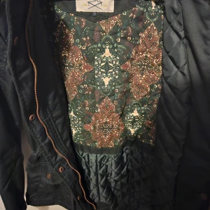 Vinterjacka  - Aldrig använd vinterjacka. Snörning i midjan. 100% polyester. Bär storleken S/M luvan är ej avtagbar. Två rejäla djupa fickor. 