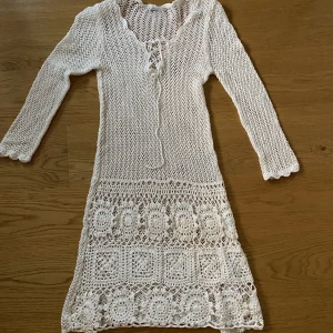 Virkad långklänning  - Superfin långklänning i virkat material med knytning framtill.