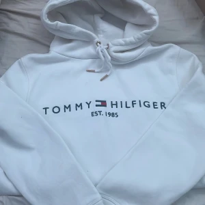 Tommy Hilfiger hoodie  - Hilfiger hoodie som har en ytterst liten fläck. Knappt använd och säljs för att den inte används. Nypris ca 900kr. Fick den i present. Kan passa S oxå.