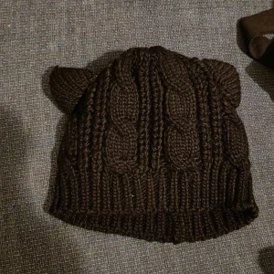 Stickad mössa med öron  - Svart, stickad mössa med öron. Endast använd ett par gånger. Vuxenstorlek.