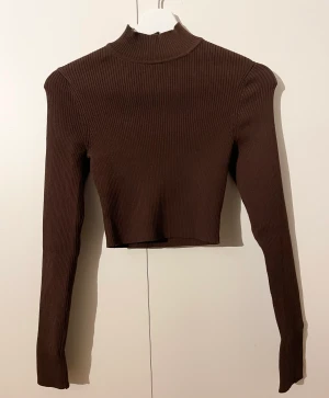 Långärmad croptop - Ribbad långärmad croptop från H&M i tight modell. Nyskick. Aldrig använd.