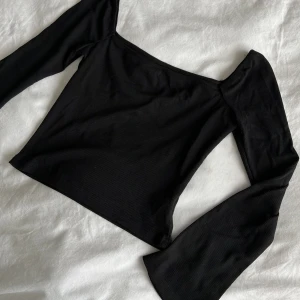 Svart top - Tröja med en rak och rektangulär urringning och vida ärmar. Jättefin och simpel.