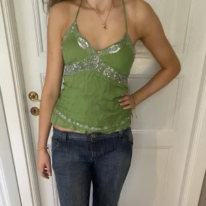 Halternecktopp med paljetter - Världens finaste gröna halternecklinne/topp med silverpaljetter💚🤩 Perfekt till fest/resor. Fint skick! Storlek passar S-M.  Skriv vid funderingar och kolla in alla andra snygga plagg jag säljer😇💗
