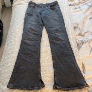 Botcut grå/svarta jeans - Säljer mina jeans från Gina då jag aldrig använder dom, dom är i en grå svart färg och har en slits nere vid foten , dom går att justera i midjan med resår , köpta för kanske ett år sen om inte kortare  men nästan aldrig använda då dom inte passar på mig❤️