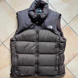 Vintage north face väst - Vintage north face 700 väst, perfekt till hösten! Säljer i brun färg som bara såldes under 90- och 00-tal (inte längre). Grym kvallité och fyllningen är 100% dun, så den håller värmen bra. Passar dam M-L, herr S-M. 
