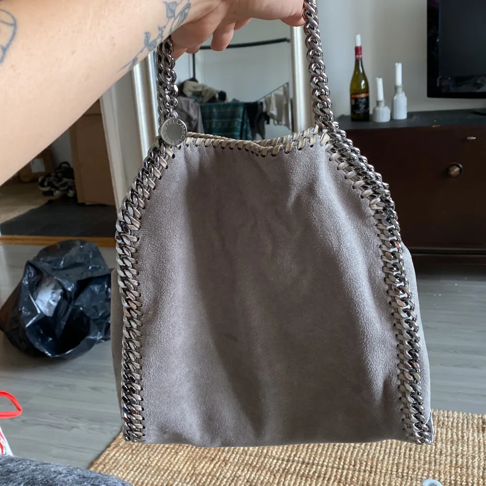 Grå stella maccartney, falabella mini tote bag. Går att ha som handväska men även crossbodybag. Välanvänd men i ok skick! Har tappat lite färg på skedjan, bilder kan skickas om så önskas! Nypris 10180kr, buda på!. Väskor.