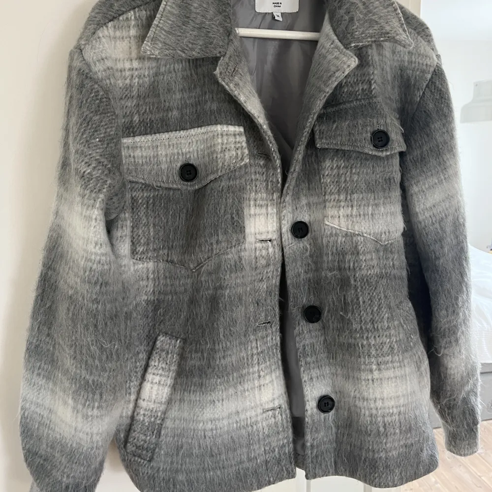 Säljer denna kappa från NA-KD med coolt grå-vitt mönster 🤍🖤 väl använd men fortfarande i fint skick 🫶🏼 skriv privat för bilder av hur den sitter på!! . Jackor.